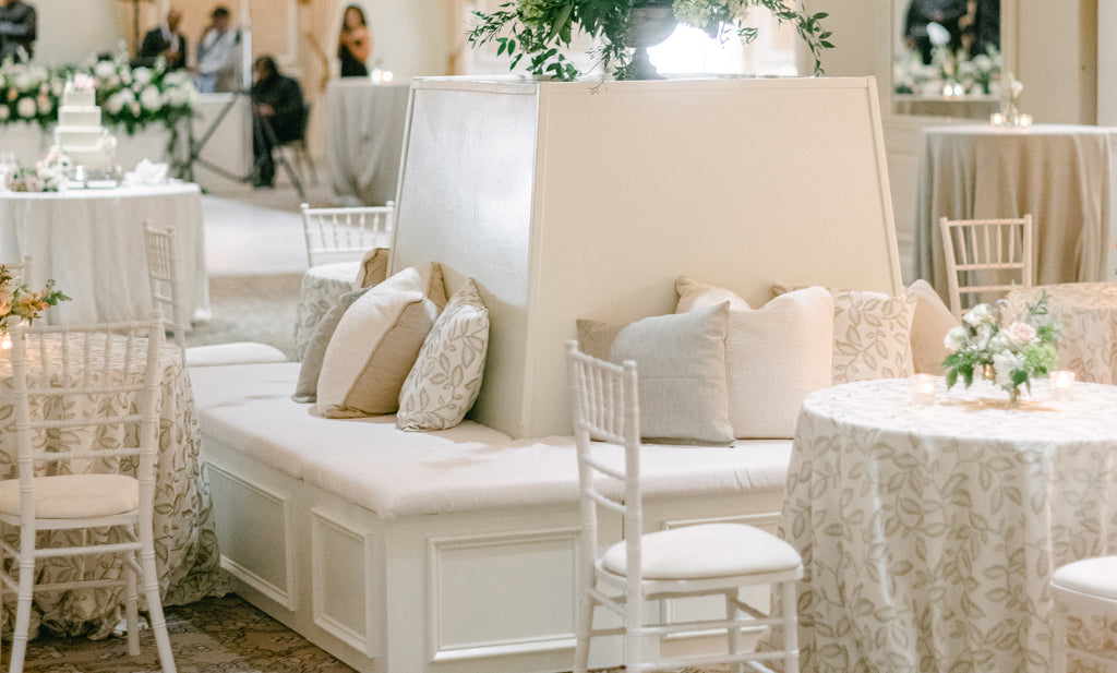 Square banquette with throw pillows in a beautiful wedding setting.