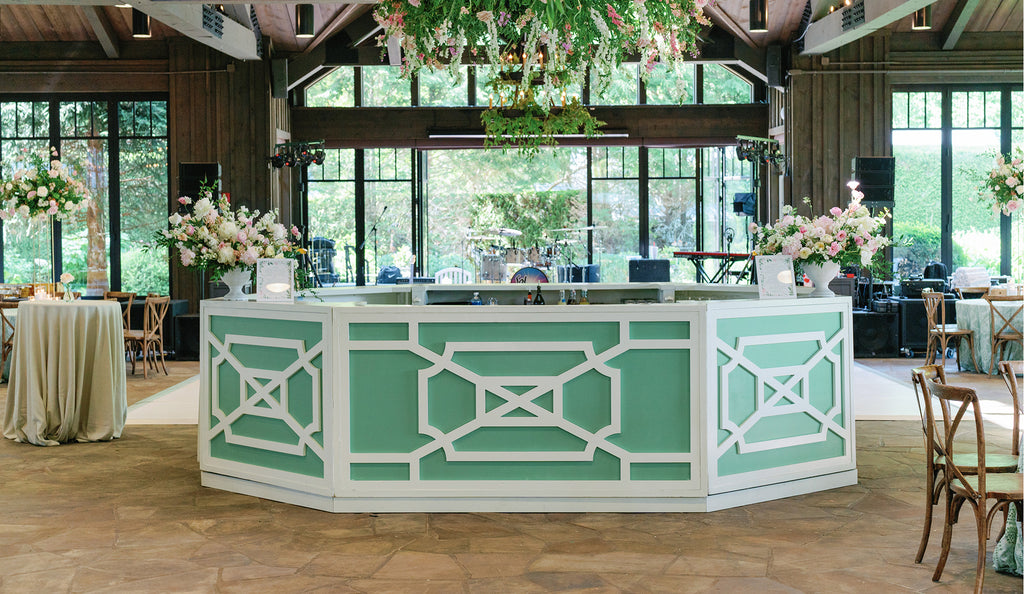 Octagonal green bar with floral arrangements set up for a beautiful wedding reception.